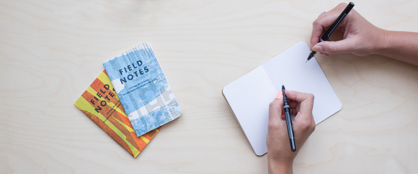Image of hands writing in note books